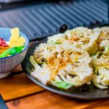 Reiben Sie den Blumenkohl mit den Gewürzen ein und vermengen Sie die Zutaten für den Dip.