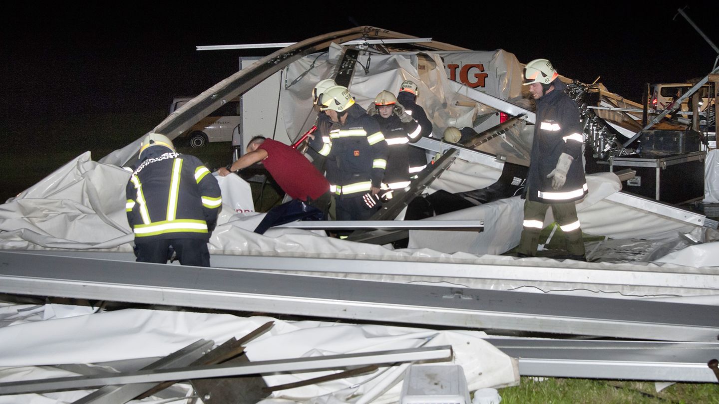 Retten statt feiern: Feuerwehrleute durchkämmen die Überreste des Zeltes nach Opfern.