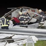 Retten statt feiern: Feuerwehrleute durchkämmen die Überreste des Zeltes nach Opfern.