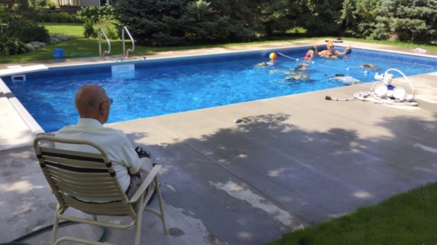Keith Davison blickt auf seinen Pool, in dem Kinder schwimmen