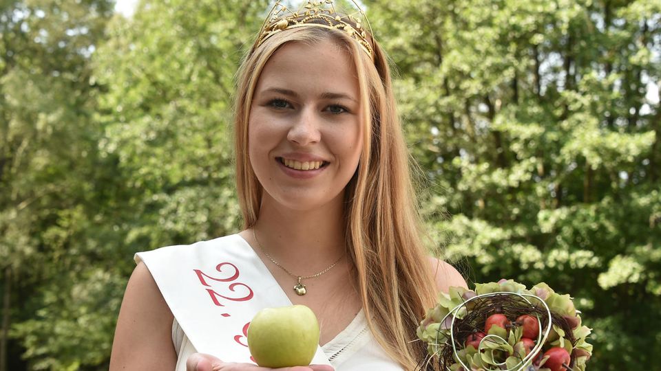 Antonia Lieske, die amtierende Gubener Apfelkönigin, präsentiert einen Apfel Antonia Lieske, die amtierende Gubener Apfelkönigin, präsentiert einen Apfel