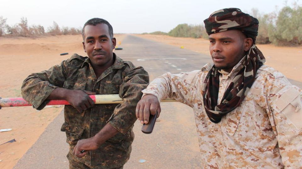 Issa Hassan (l.) am Schlagbaum der Grenze Niger zu Libyen. Er und seine Männer vom Stamm der Tubu patrouillieren in dem unsicheren Gebiet