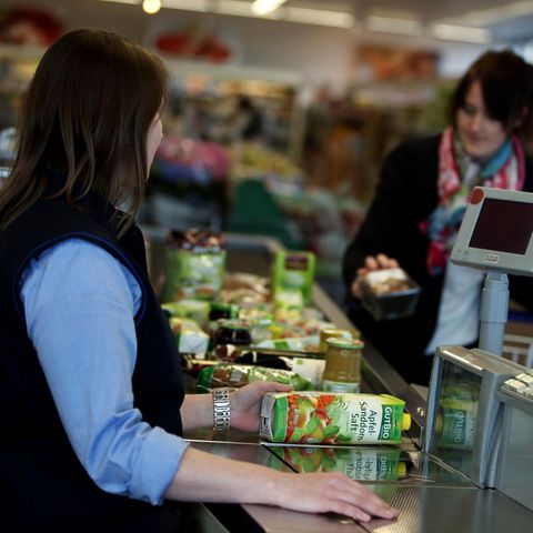 Eine Kassiererin sitzt bei Aldi an der Kasse