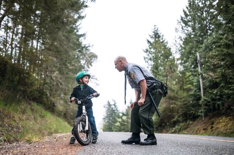 Polizist ermahnt Kind auf einem Fahrrad