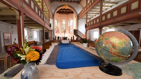 Ein Bett steht in der Michaeliskirche in Neustadt am Rennsteig in Thüringen: Radfahrer, Wanderer und interessierte Touristen erhalten hier eine Übernachtungsmöglichkeit für bis zu drei Personen im Innenraum der Kirche.