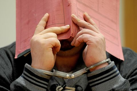 Niels H. versteckt sich im Gerichtssaal hinter einem Aktenordner