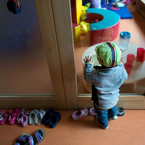 Ein Kleinkind steht an einer Glasscheibe in einer Kindertagesstätte in Dresden