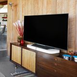 Sonos Playbase steht in einem Wohnzimmer unter dem Fernseher