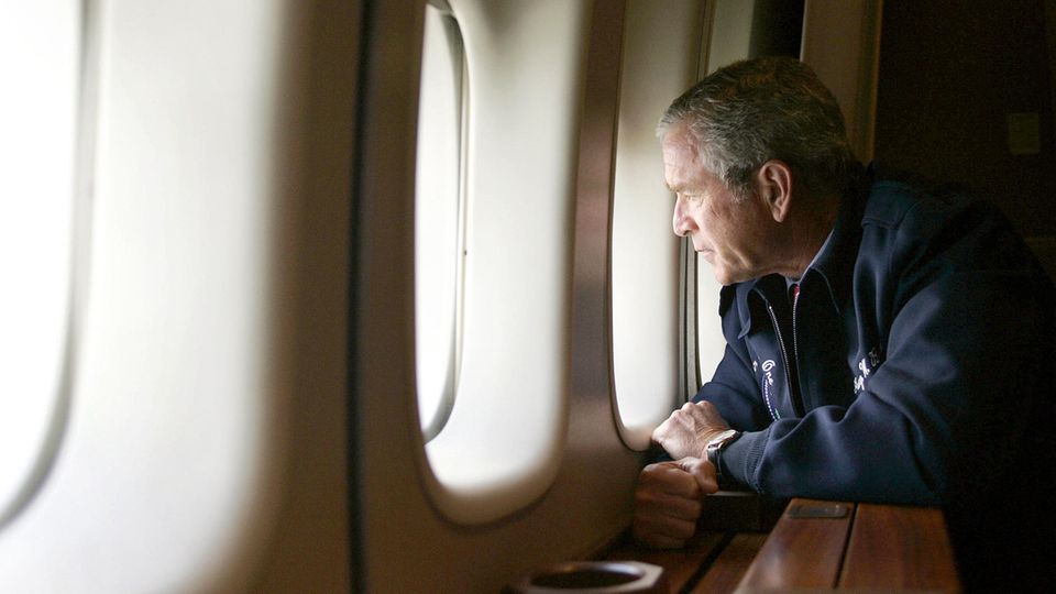 George W. Bush schaut aus seiner Air Force One. Darunter liegt das überflutete New Orleans. Es ist der 31. August 2005.