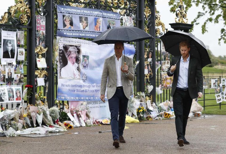 Die Prinzen William und Harry vor dem Haupttor des Kensington Palastes William und Harry schauen sich vor dem Kensington Palast niedergelegte Blumen an