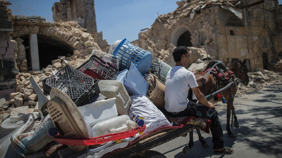 Die meisten Straßen von Aleppo sind weiter menschenleer. Ein Mann transportiert Plastikabfall durch die Stadt