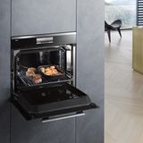 Der Miele Dialoggarer in einer Einbau-Küche. Die dicke Türklappe ist geöffnet