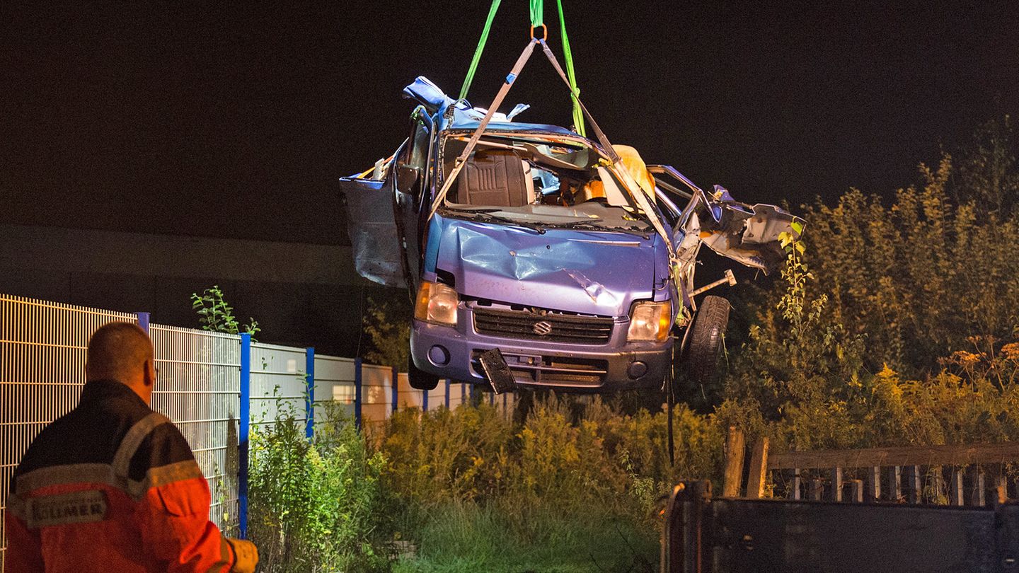 Das Fahrzeugwrack wird nach dem Zusammenstoß eines Autos mit einem ICE an der Bahnstrecke bei Bönen in Nordrhein-Westfalen aus einem Gebüsch auf ein Bergungsfahrzeug gehoben. 