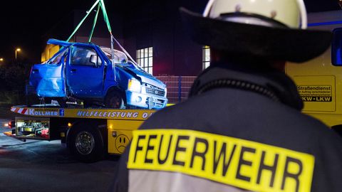 Das Fahrzeugwrack wird nach dem Zusammenstoß eines Autos mit einem ICE an der Bahnstrecke bei Bönen in Nordrhein-Westfalen aus einem Gebüsch auf ein Bergungsfahrzeug gehoben. 