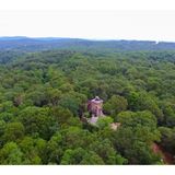 Das Gebäude ist von tiefem Wald umgeben.