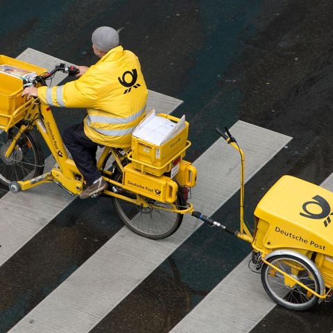 Briefzustellung bald nur noch an wenigen Wochentagen? Ein Briefträger der Deutschen Post ist mit einem E-Bike unterwegs.