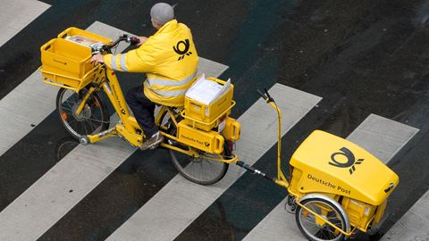 Briefzustellung bald nur noch an wenigen Wochentagen? Ein Briefträger der Deutschen Post ist mit einem E-Bike unterwegs.