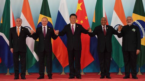 Die fünf Regierungschef der Brics-Staaten halten sich an den Händen auf dem roten Teppich in Xiamen, China.