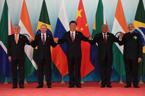 Die fünf Regierungschef der Brics-Staaten halten sich an den Händen auf dem roten Teppich in Xiamen, China.