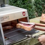 Der Grill muss drei Minuten aufheizen, dann kann das Steak auf den Rost.