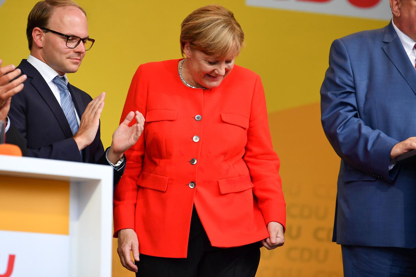 Bundeskanzlerin Angela Merkel schaut bei einer Wahlkampfveranstaltung in Heidelberg auf einen Fleck auf ihrer Jacke. Aus dem Publikum hatte jemand eine Tomate auf einen Tisch geworfen, der vor ihr stand