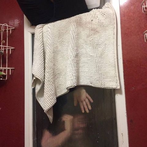 Die junge Frau hängt kopfüber im Fenster