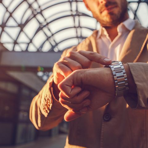 Ein Mann schaut auf seine Armbanduhr