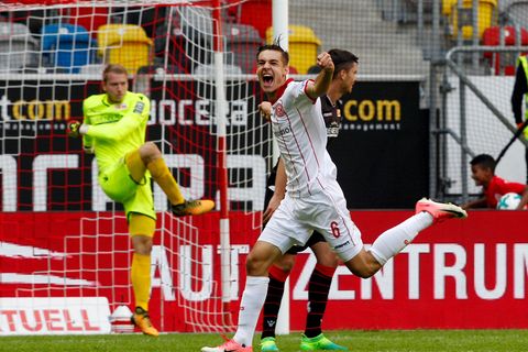 Florian Neuhaus (M.), der Düsseldorfer Torschütze zum 3:2, dreht jubelnd ab. Beim Berliner Torwart ist der Ärger groß