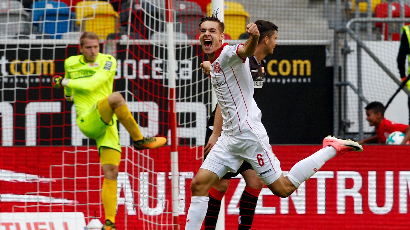 Florian Neuhaus (M.), der Düsseldorfer Torschütze zum 3:2, dreht jubelnd ab. Beim Berliner Torwart ist der Ärger groß