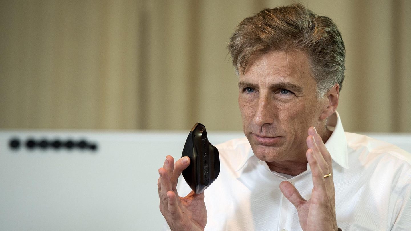 Logitech-CEO Bracken Darrell hält eine Maus des Unternehmens hoch