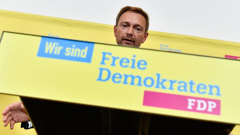 Christian Lindner zeigt ein Schild mit der Aufschrift "Wir sind Freie Demokraten - FDP" - Er sieht keine Steuerschuld