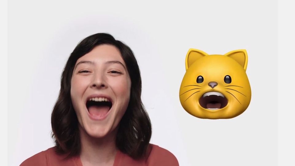 iPhone X Selfie Animoji Cat Emoji Katze Eine Frau lacht mit offenem Mund, daneben imitiert das Katzen-Animoji ihre Mimik