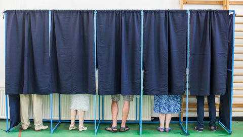 Wähler in Wahlkabinen