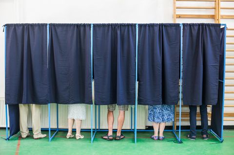 Wähler in Wahlkabinen