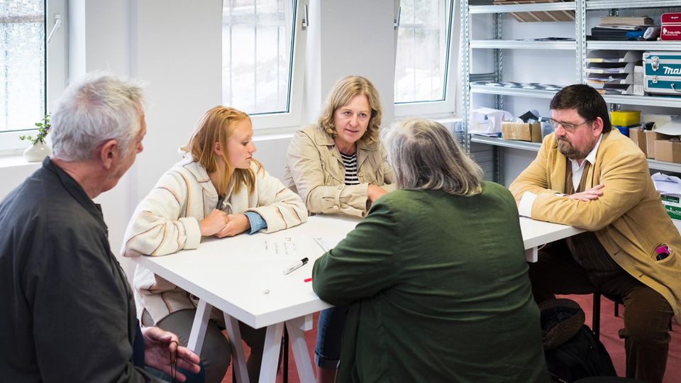 Im Hinterzimmer eines kleinen Ladenlokals in Kassel hat sich eine kleine Gruppe an einem Tisch eingefunden, um ein großes Thema zu lösen Eine kleine Gruppe im Hinterzimmer eines kleinen Ladenlokals in Kassel