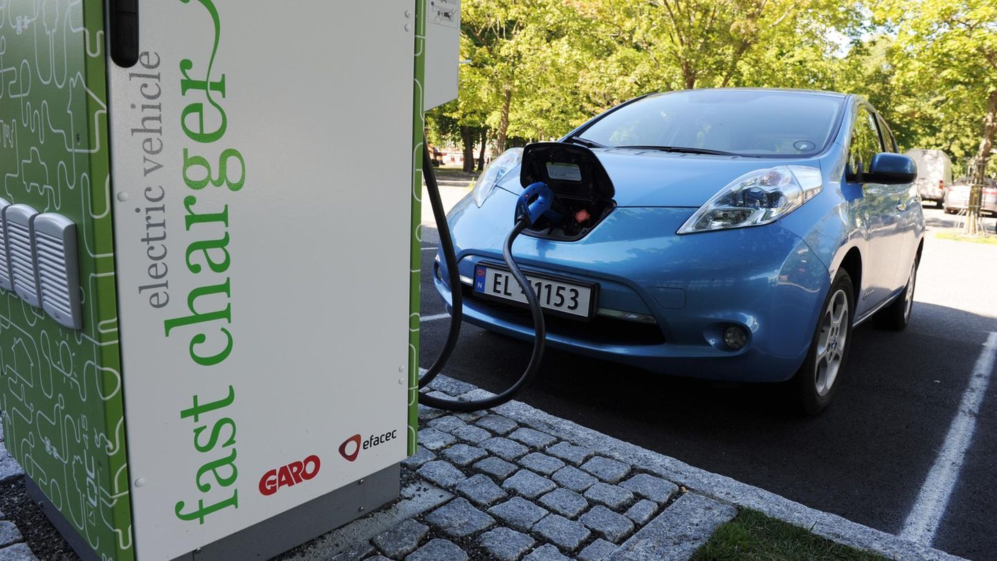 Ein Auto steht an einer Ladestation und ist zum Laden der Batterien angeschlossen