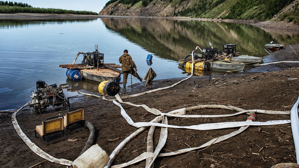 Sibirien: Etwas wackelig klemmen Motoren und Pumpen auf den Booten. Durch Feuerwehrschläuche gelangt das Wasser in die Hänge Etwas wackelig klemmen Motoren und Pumpen auf den Booten. Durch Feuerwehrschläuche gelangt das Wasser in die Hänge