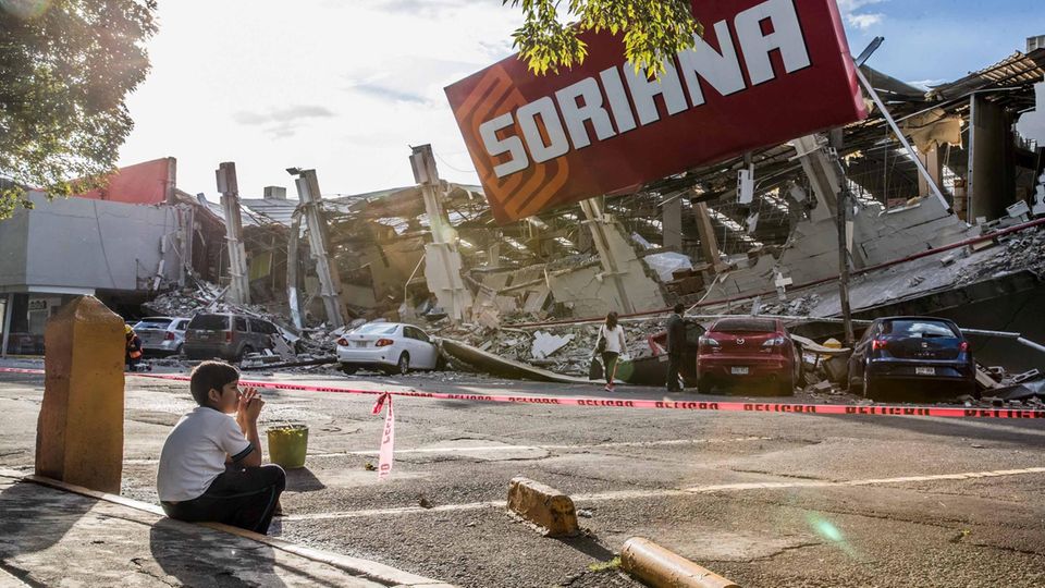 Erdbeben in Mexiko: Ein Junge sitzt vor einem zusammengebrochenen Supermarkt
