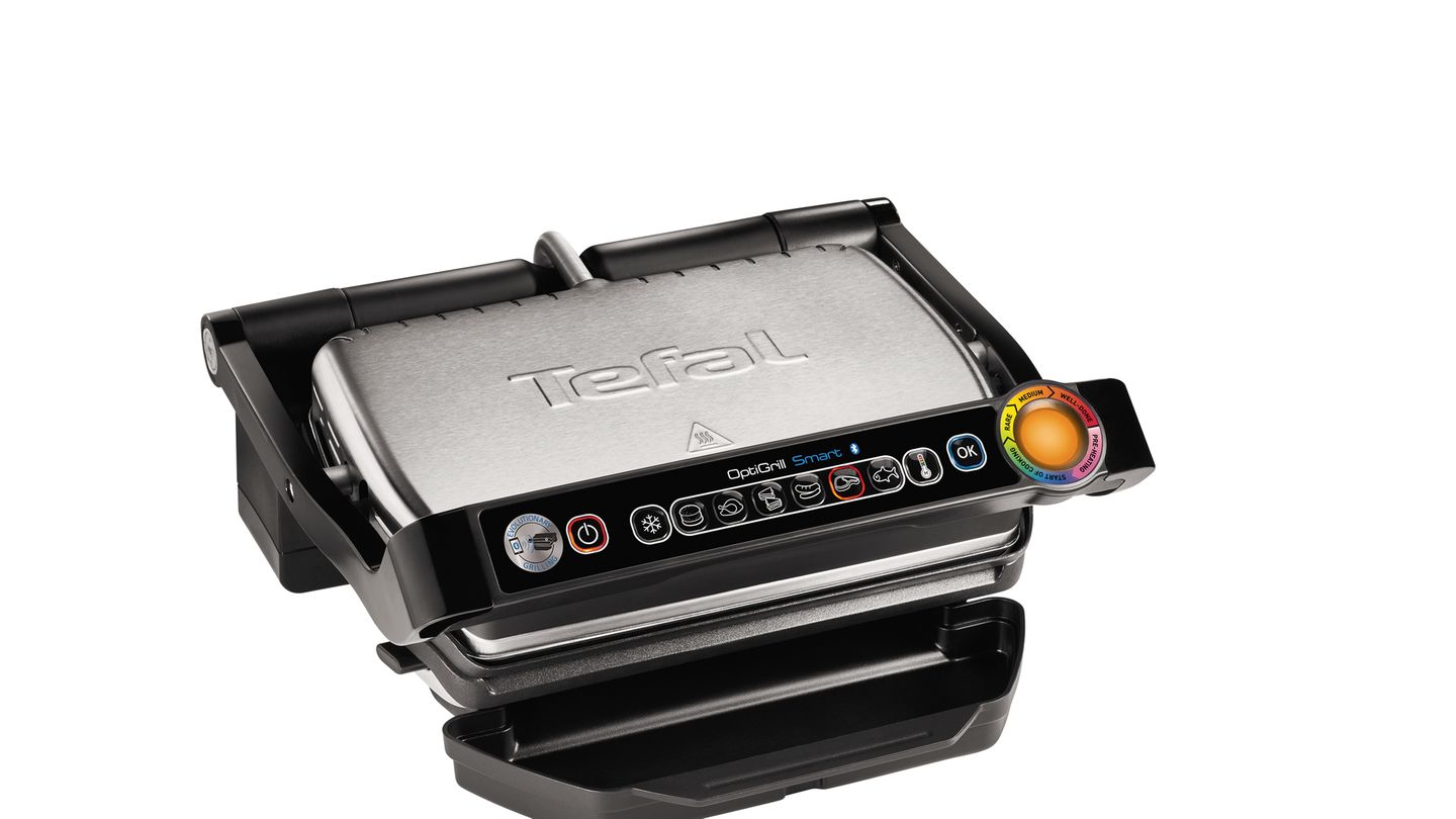 Tefal Optigrill  Sieht nicht so aus, ist aber einer: ein Grill. Genauer ein High-Tech-Grill, der die richtige Garstufe nicht dem Zufall überlässt. Der Tefal OptiGrill erkennt durch einen Sensor automatisch die Dicke des Grillguts und richtet den Grillvorgang danach aus. Über die sechs voreingestellten Grillprogramme passen sich Temperatur und Zeit optimal an die Art des Grillguts an. Die automatische Anzeige gibt im Farbkreis präzise an, in welcher Garstufe sich das Grillgut gerade befindet: egal ob blutig, medium oder "well-done". So werden Burger, Geflügel, Sandwiches, Würstchen, Steaks und Fisch stets punktgenau gegrillt und es bleibt mehr Zeit für die Gäste. Mit einer Grillfläche von 600 Quadratzentimetern lassen sich bis zu vier kleine Portionen gleichzeitig grillen.
