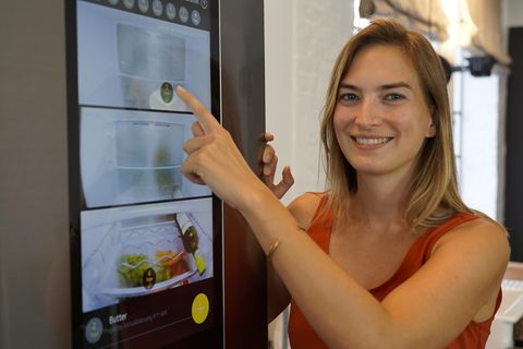 stern.de-Genuss-Redakteurin Denise Wachter vor dem vernetzten Samsung-Kühlschrank in einer smarten Küche.  Das Display zeigt, was im Kühlschrank liegt.  