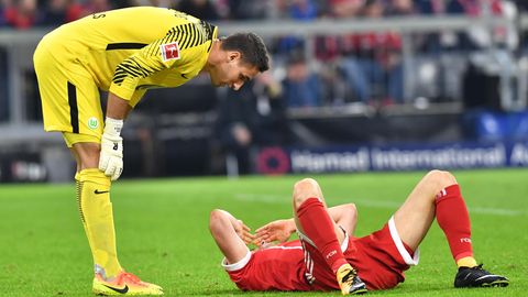Robert Lewandowski (r.) vom FC Bayern München liegt vom VfL Wolfsburg Torwart Koen Casteels nach einem Zweikampf auf dem Boden