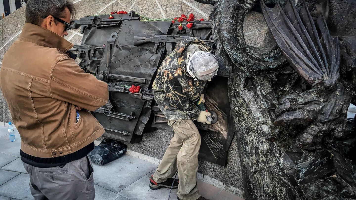 Panne auf Kalaschnikow-Denkmal: Mit einer Flex entfernen Arbeiter die Abbildung des Sturmgewehrs vom Typ StG 44