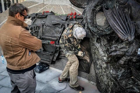 Panne auf Kalaschnikow-Denkmal: Mit einer Flex entfernen Arbeiter die Abbildung des Sturmgewehrs vom Typ StG 44