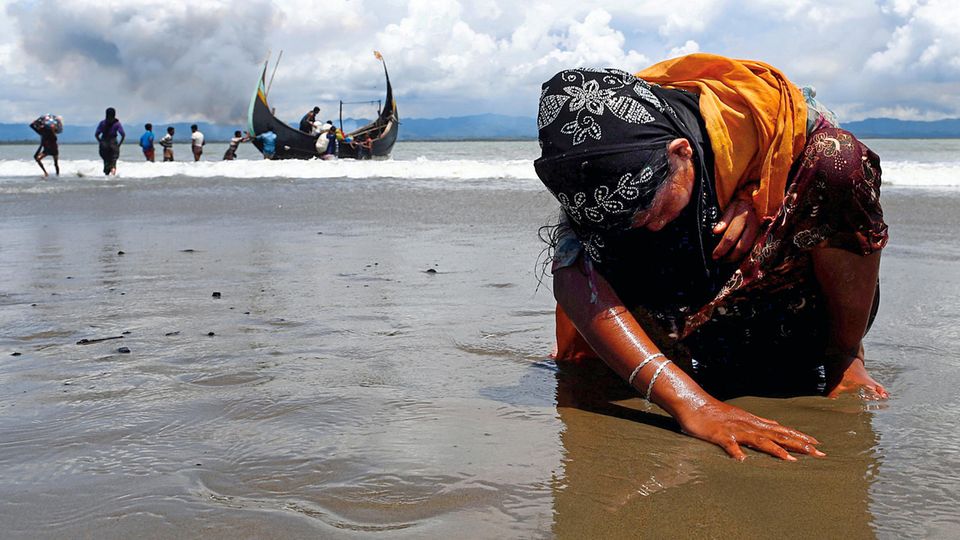 Muslimische Minderheit in Myanmar: Erschöpft, aber in Sicherheit: Eine Flüchtlingsfrau berührt den Strand des Grenzflusses Naf Erschöpft, aber in Sicherheit: Eine Flüchtlingsfrau berührt den Strand des Grenzflusses Naf