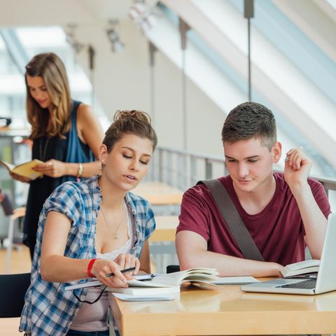 Vier junge Studierende in der Universitätsbibliothek