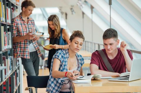 Vier junge Studierende in der Universitätsbibliothek