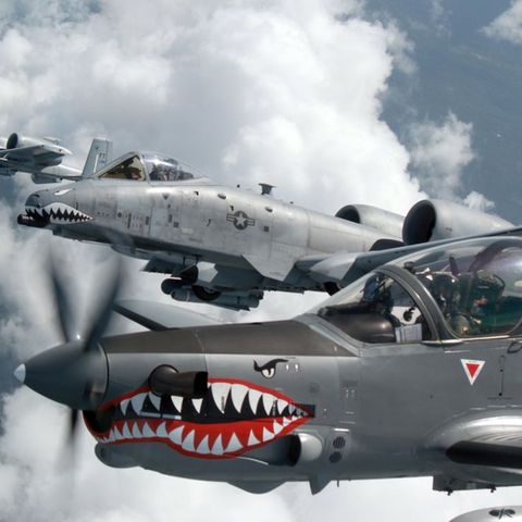 Im Vordergrund fliegt die kleine Super Tucano, dahinter sind zwei A-10 Warthogs zu sehen.