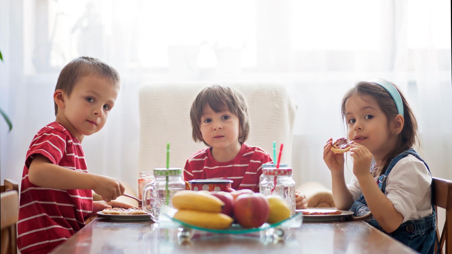 Drei Kinder am Frühstückstisch