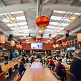 In der Halle finden unter den roten Lampions 450 Menschen an drei verschiedenen Sitzzonen mit ganz unterschiedlicher Bestuhlung Platz.