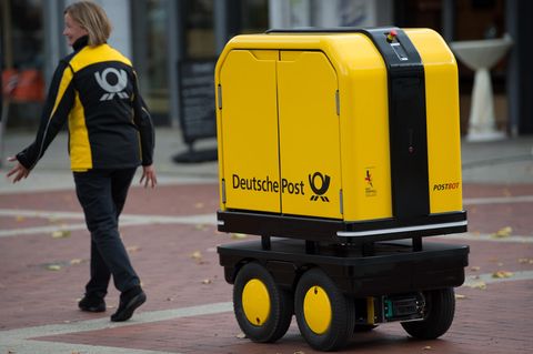 Der Begleitroboter folgt einer Zustellerin der Deutschen Post